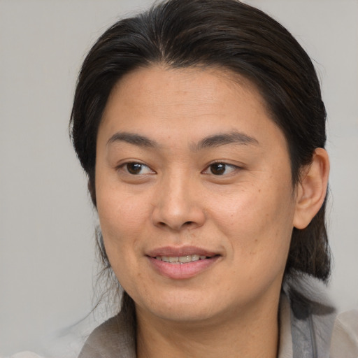 Joyful asian adult female with medium  brown hair and brown eyes