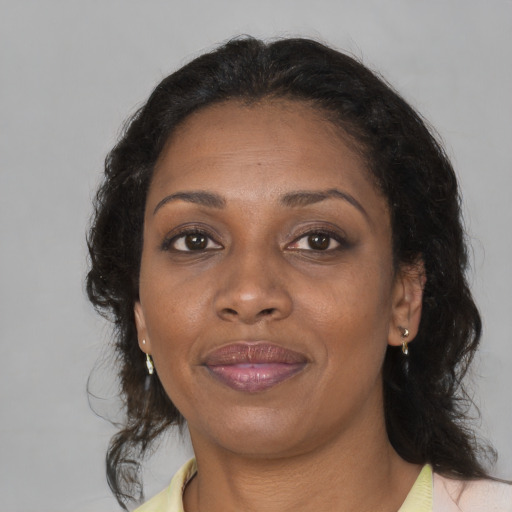 Joyful black adult female with medium  brown hair and brown eyes