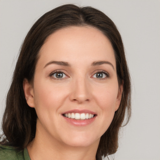 Joyful white young-adult female with medium  brown hair and grey eyes