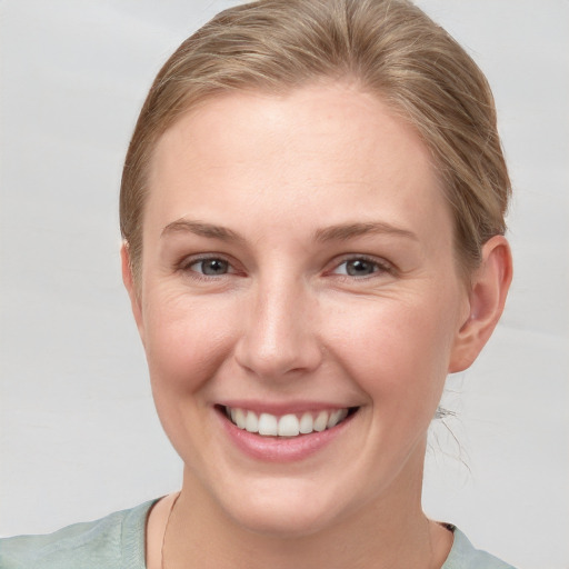 Joyful white young-adult female with short  brown hair and grey eyes