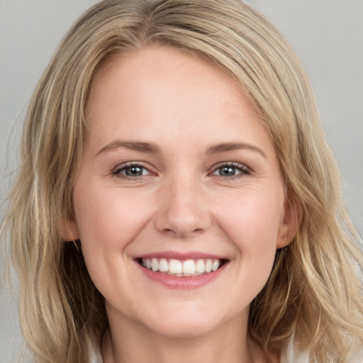 Joyful white young-adult female with medium  brown hair and grey eyes