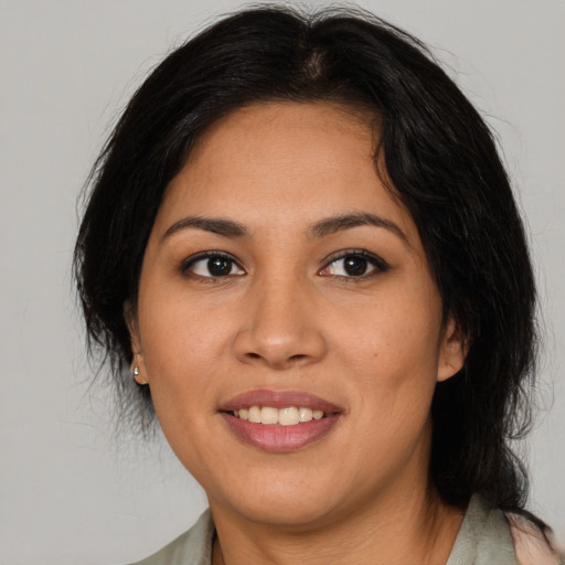 Joyful latino young-adult female with long  brown hair and brown eyes