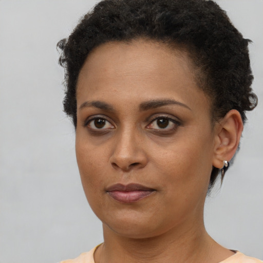 Joyful black young-adult female with short  brown hair and brown eyes
