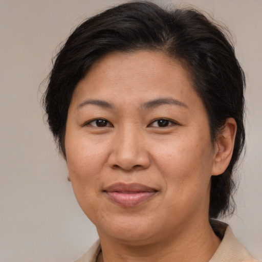 Joyful asian adult female with medium  brown hair and brown eyes