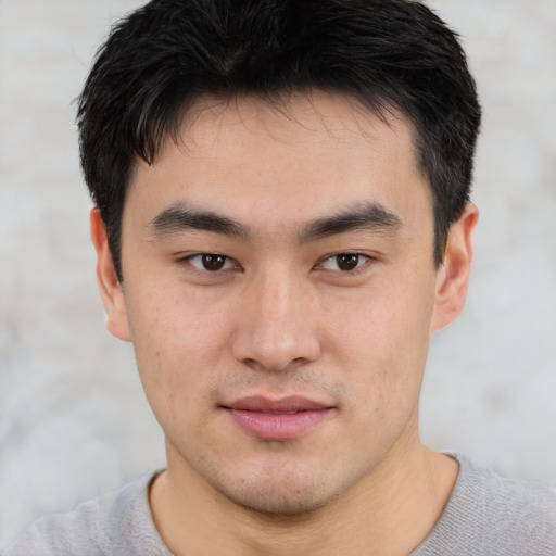 Joyful asian young-adult male with short  black hair and brown eyes