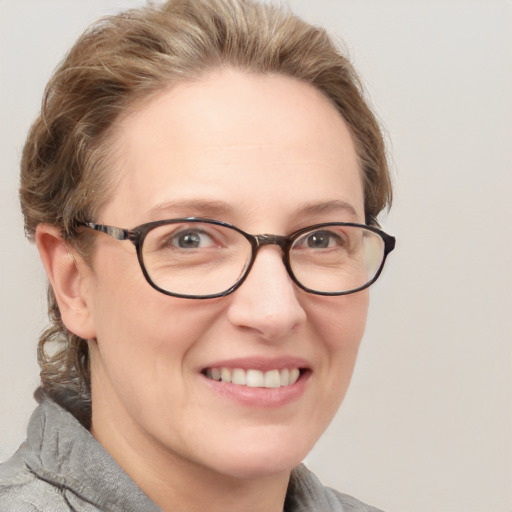 Joyful white adult female with short  brown hair and blue eyes