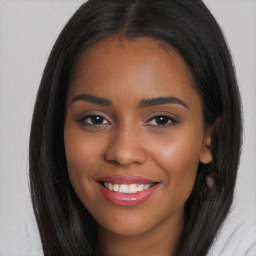 Joyful black young-adult female with long  brown hair and brown eyes