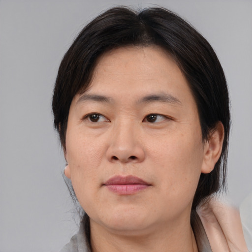 Joyful asian adult female with medium  brown hair and brown eyes