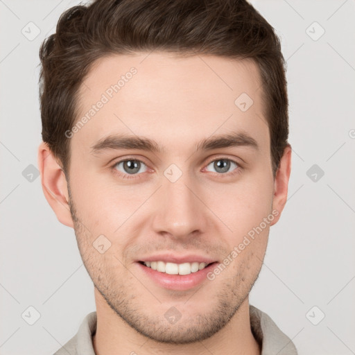 Joyful white young-adult male with short  brown hair and grey eyes