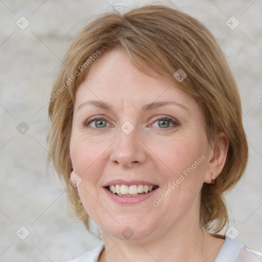 Joyful white adult female with medium  brown hair and blue eyes