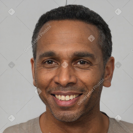 Joyful black adult male with short  black hair and brown eyes