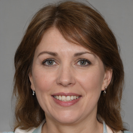 Joyful white adult female with medium  brown hair and blue eyes