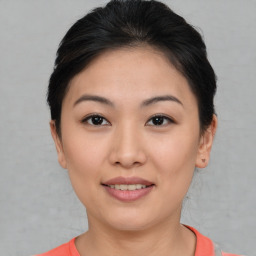 Joyful asian young-adult female with short  brown hair and brown eyes