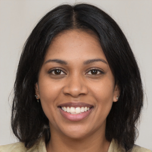 Joyful black young-adult female with long  black hair and brown eyes