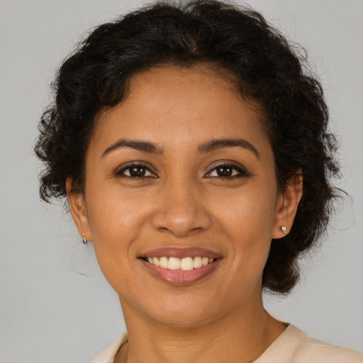 Joyful latino young-adult female with short  brown hair and brown eyes