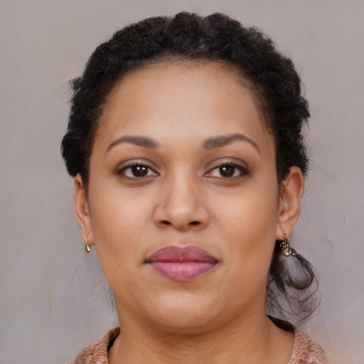 Joyful black young-adult female with long  brown hair and brown eyes