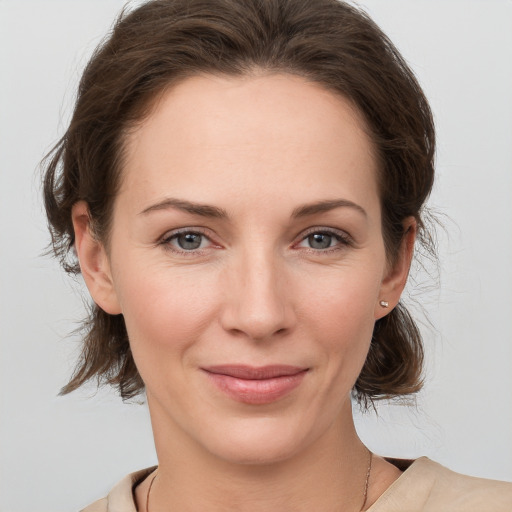 Joyful white young-adult female with medium  brown hair and grey eyes