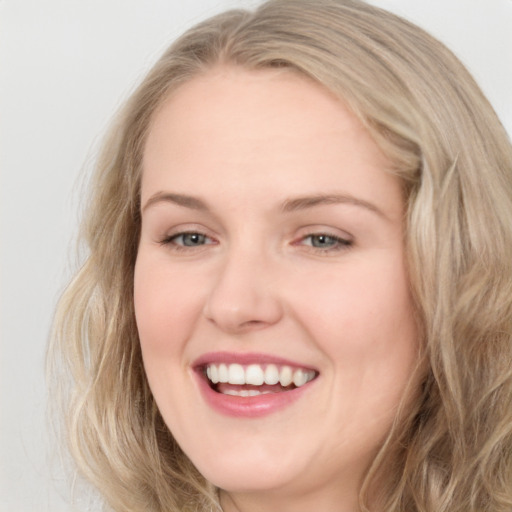 Joyful white young-adult female with long  brown hair and blue eyes