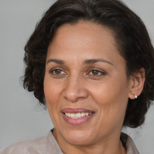 Joyful latino adult female with medium  brown hair and brown eyes