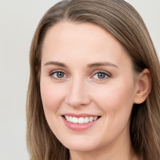 Joyful white young-adult female with long  brown hair and grey eyes