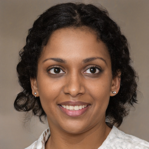 Joyful black young-adult female with medium  brown hair and brown eyes