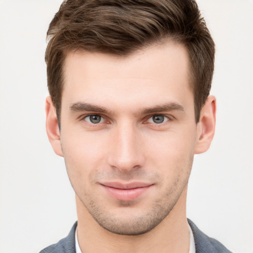 Joyful white young-adult male with short  brown hair and grey eyes