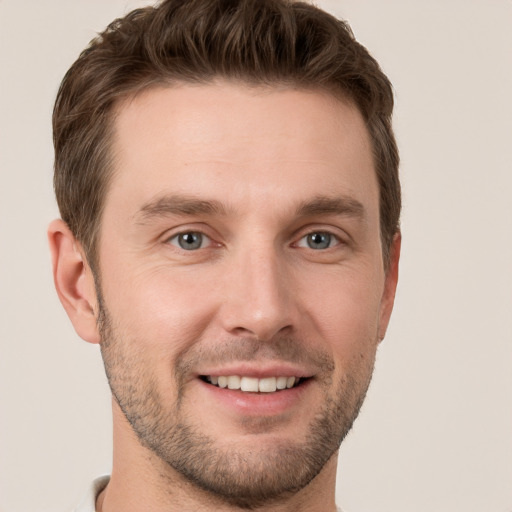 Joyful white young-adult male with short  brown hair and grey eyes