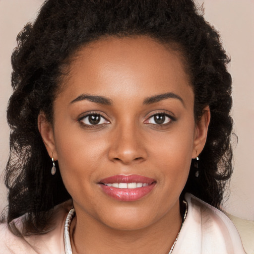 Joyful black young-adult female with long  brown hair and brown eyes