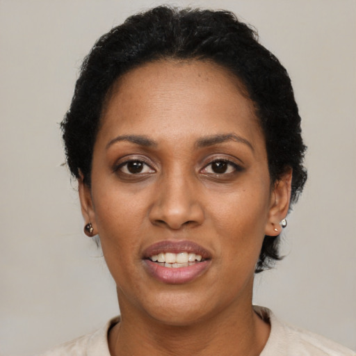 Joyful black adult female with short  black hair and brown eyes