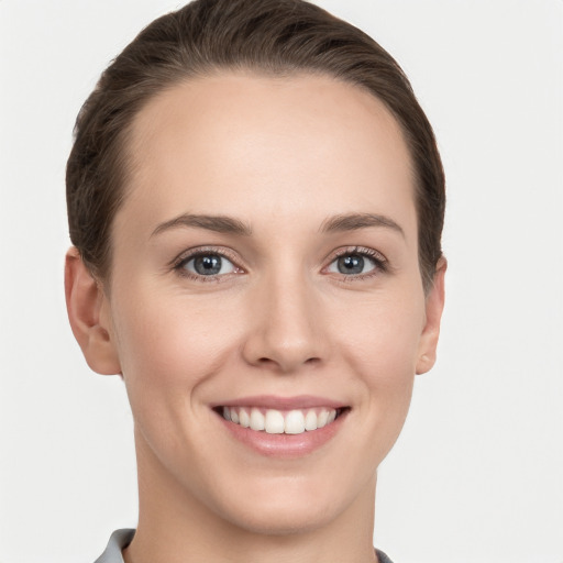 Joyful white young-adult female with short  brown hair and grey eyes