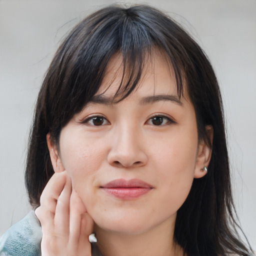 Joyful asian young-adult female with medium  brown hair and brown eyes