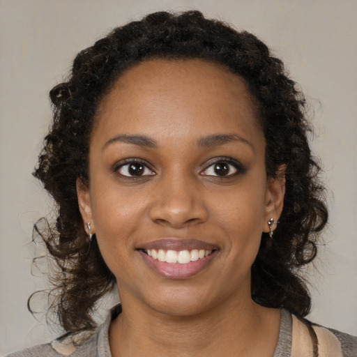 Joyful black young-adult female with medium  black hair and brown eyes