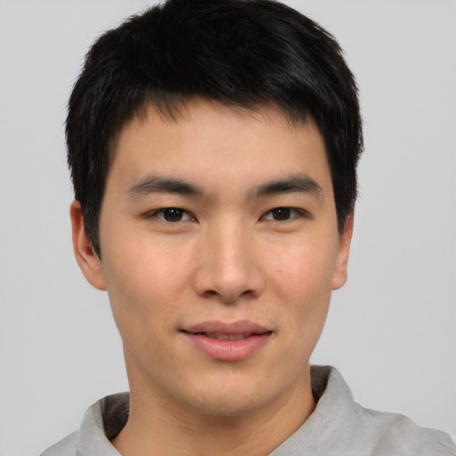 Joyful asian young-adult male with short  brown hair and brown eyes