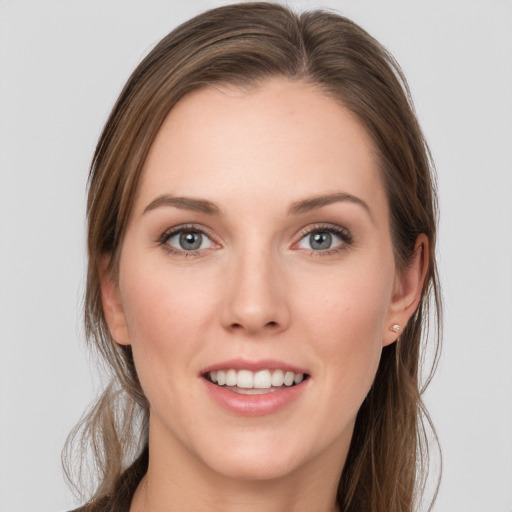 Joyful white young-adult female with long  brown hair and blue eyes