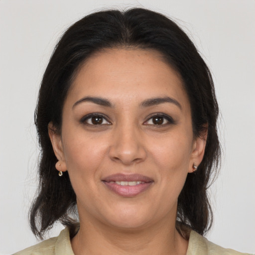 Joyful latino adult female with medium  brown hair and brown eyes