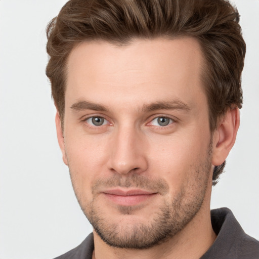 Joyful white young-adult male with short  brown hair and grey eyes