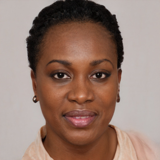 Joyful black young-adult female with short  black hair and brown eyes