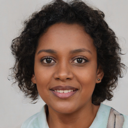 Joyful black young-adult female with medium  brown hair and brown eyes