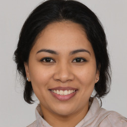 Joyful latino young-adult female with medium  brown hair and brown eyes