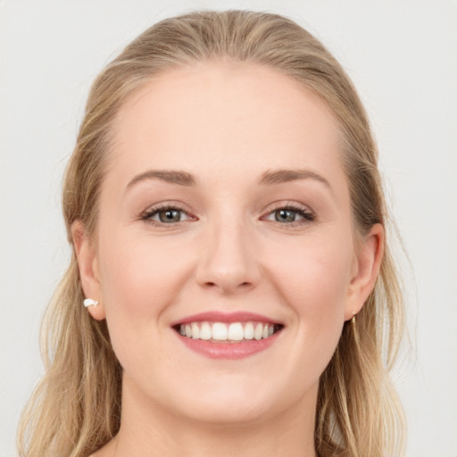 Joyful white young-adult female with long  brown hair and blue eyes