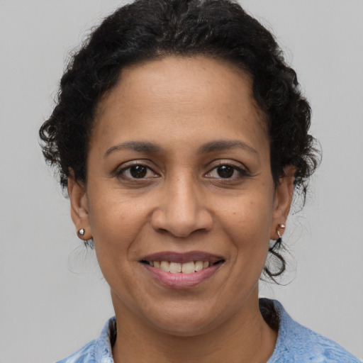 Joyful latino adult female with medium  brown hair and brown eyes