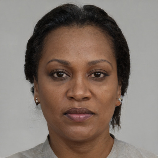 Joyful black adult female with short  black hair and brown eyes