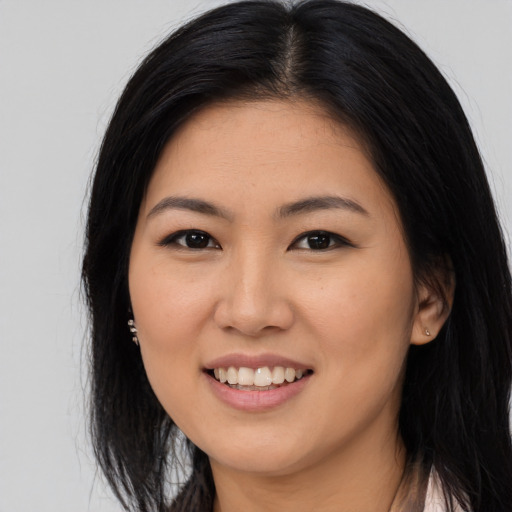Joyful asian young-adult female with long  black hair and brown eyes