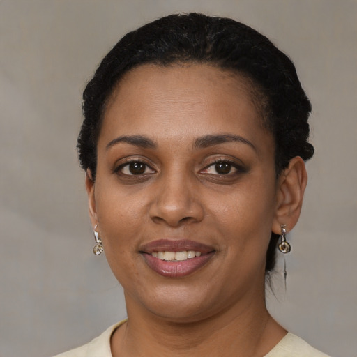 Joyful black young-adult female with short  black hair and brown eyes
