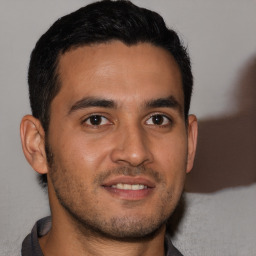 Joyful latino young-adult male with short  brown hair and brown eyes