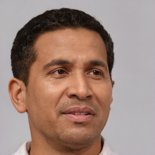 Joyful latino adult male with short  brown hair and brown eyes