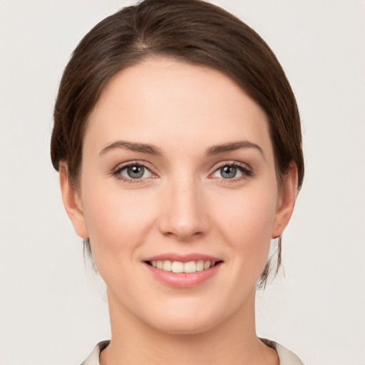 Joyful white young-adult female with medium  brown hair and green eyes