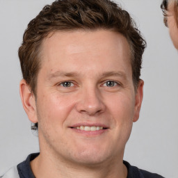 Joyful white adult male with short  brown hair and grey eyes