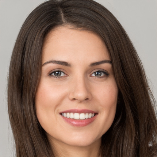 Joyful white young-adult female with long  brown hair and brown eyes