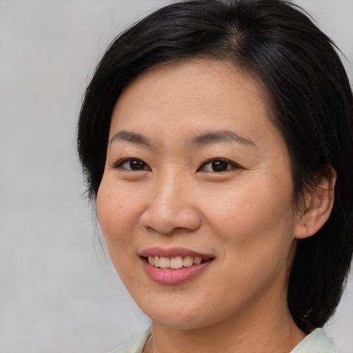 Joyful asian young-adult female with medium  brown hair and brown eyes